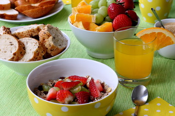 Healthy colorful breakfast: cereals with fresh fruits, wholemeal bread and fresh orange juice