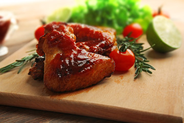 Grilled chicken wings with garden-stuff on cutting board