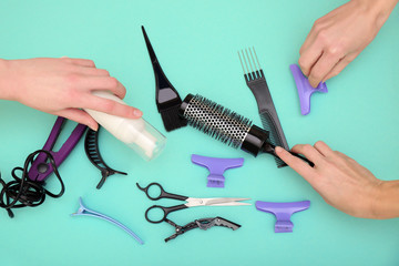 Human hands holding hairdresser set on turquoise background