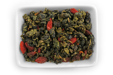 Oolong tea leaves in bowl, isolated on white