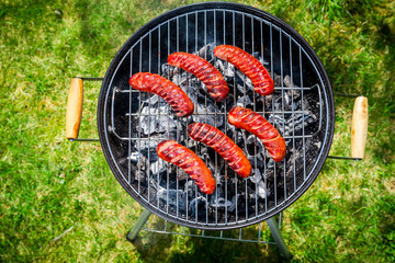 Spicy sausages with rosemary on garden grill