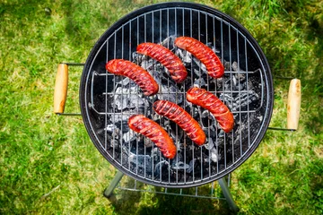 Photo sur Plexiglas Grill / Barbecue Spicy sausages with rosemary on garden grill