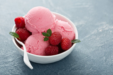 Raspberry ice cream in white bowl