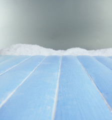 Blue wood planks with snow on grey background