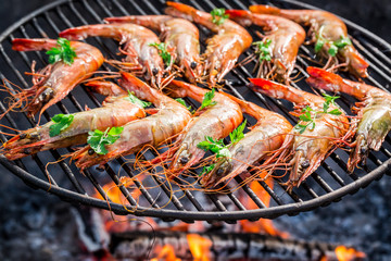 Big shrimps with lemon and parsley on hot grill