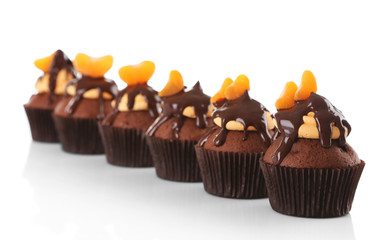 Tasty cupcakes with slice of mandarin and chocolate, isolated on white