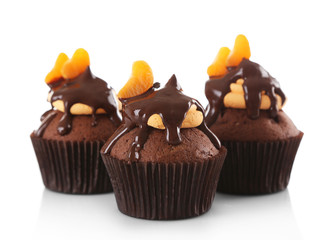Three tasty cupcakes with slice of mandarin and chocolate, isolated on white