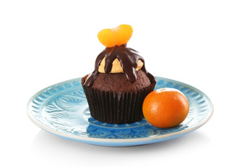 Tasty cupcake with slice of mandarin and chocolate on a plate, isolated on white