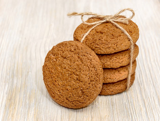 Stack oatmeal cookies tied with thread on a wooden background