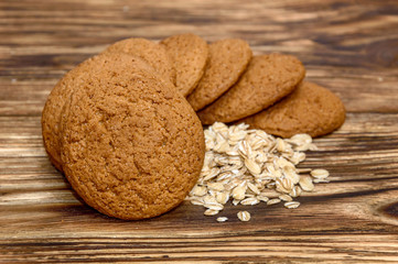 Oatmeal cookies with oat flakes on wooden background