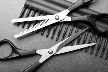 Barber set with comb and scissors on grey background, close up - obrazy, fototapety, plakaty