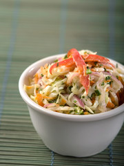 Serving of coleslaw on green background