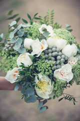 Obraz na płótnie Canvas Wedding bouquet close-up, beautiful tender wedding bouquet of mixed flowers and in hands of the bride