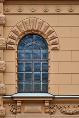 Window with arch and a bas-relief on a background of beige wall. From the series window of Saint-Petersburg.