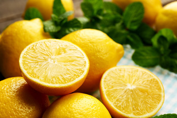 Sliced fresh lemons with green leaves on napkin closeup