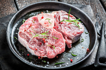 Closeup of red meat with rosemary and pepper ready for grilling