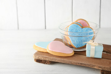 Valentine heart cookies in glass bowl with present box on wooden background