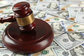 Obraz na płótnie Canvas Law gavel on dollars background, closeup