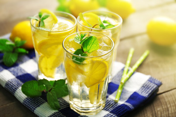 Group of lemonades with lemons and mint on cloth, closeup