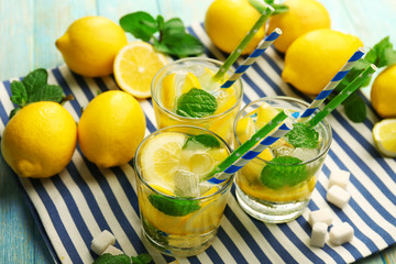 Composition of lemonades,  lemons and mint on cloth, closeup