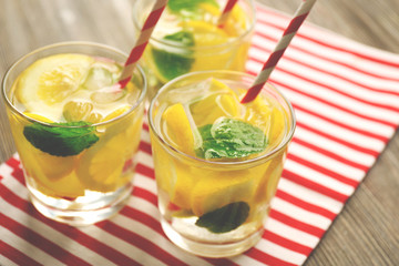 Group of lemonades with lemon and mint on striped cloth, closeup
