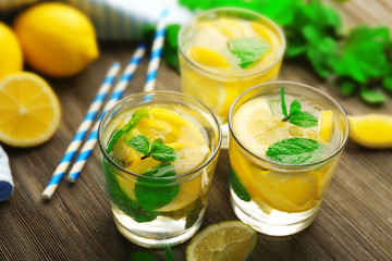 Composition of lemonades,  lemons and mint on wooden table background, closeup