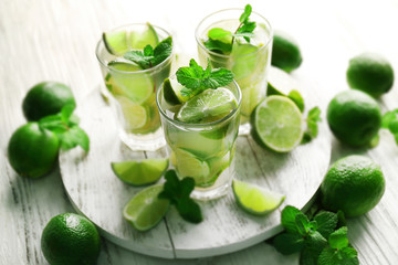 Fresh mojito drinks with lime, lemon and mint on wooden table