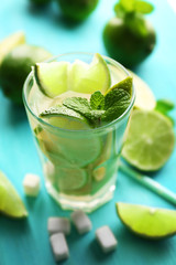 Fresh mojito drinks with lime, lemon and mint on blue background