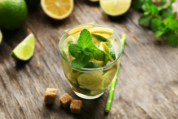 Fresh mojito drink with lime, lemon and mint on wooden table