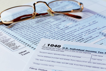 1040 Individual Income Tax Return Form with  metal rimmed glasses, close up