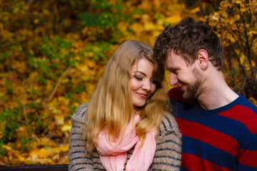 Lovers couple in autumn park on bench