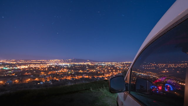 2 in 1! The evening cityscape on the mountain with the car. Time lapse. Wide angle