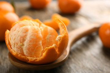 Fresh, delicious peeled tangerine on a rustic table, close up