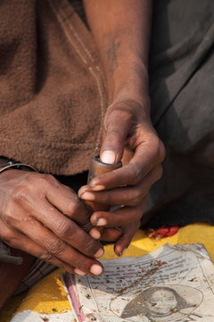 Sadhu is preparing his chillum to smoke ganja (marihuana)
