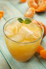 Fresh cocktail with tangerine and ice on wooden background, close up