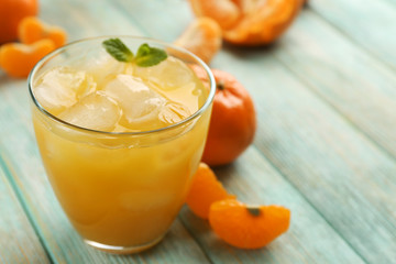 Fresh cocktail with tangerine and ice on wooden background, close up