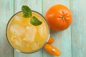 Fresh cocktail with tangerine and ice on wooden background, top view