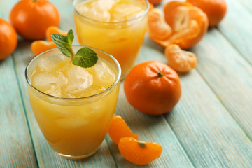 Fresh cocktails with ice, mint and tangerines on the wooden table, close up