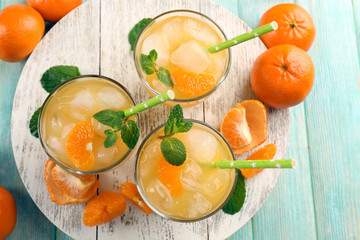Fresh cocktails with ice, mint and tangerines on a white wooden board, top view