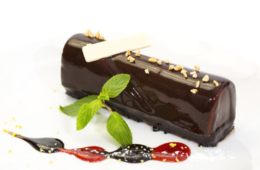 chocolate dessert decorated with jam and mint on a white background
