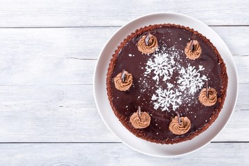 chocolate cake decorated with chocolate chips and icing-sugar snowflake, close-up