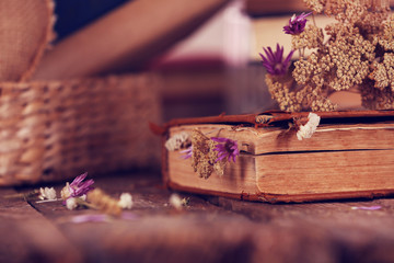 Obraz na płótnie Canvas Book with dried flowers on wooden table, close up