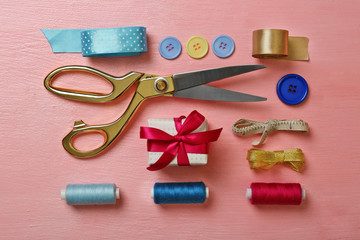 Sewing creative accessories on pink surface, top view