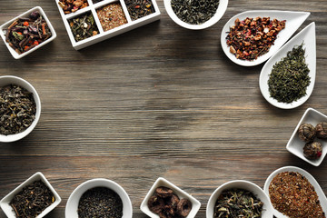 Tea concept. Different kinds of tea in ceramic bowls on wooden background