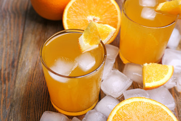 Fototapeta na wymiar Two orange juices with cubes of ice and orange, closeup