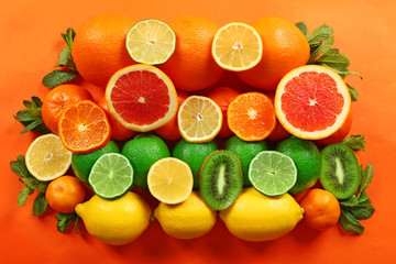 Fototapeta na wymiar Set of different citrus fruit on orange background