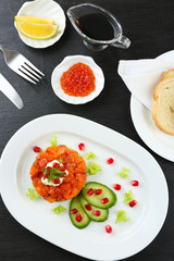 Fresh tartar with salmon, cucumber and pomegranate seeds on white plate