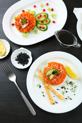 Fresh tartar with salmon, avocado, cucumber and lemon on white plate