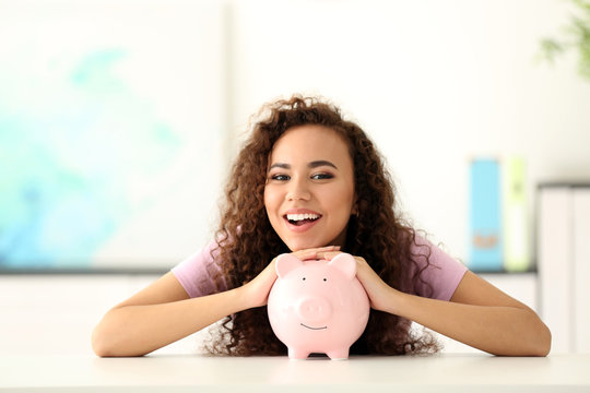 Beautiful Young Girl With Piggy Bank In Office