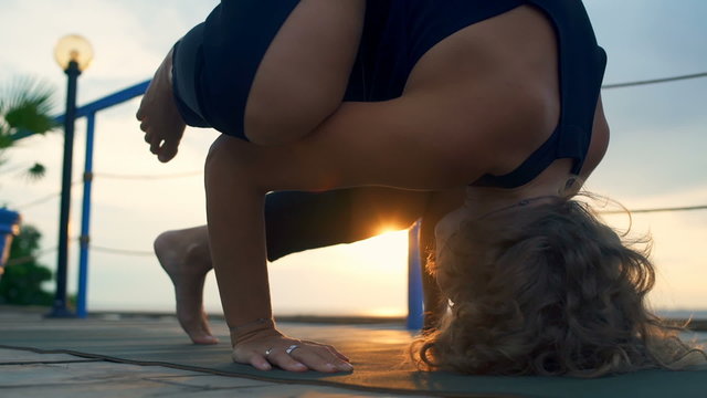 close up young female practicing yoga on the terrace by the sea 